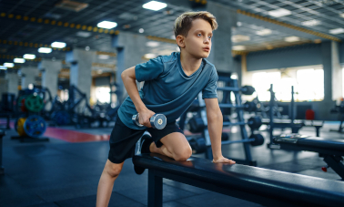 Boy with dumbbell in gym
