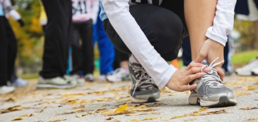 runner kneeling to adjust laces
